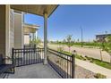 Relaxing front porch with black metal railing offering a view of the neighborhood and street at 24374 E 42Nd Ave, Aurora, CO 80019