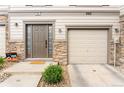 Beautiful townhome showcasing a private entrance, attached garage, stone accents, and manicured landscape at 992 Burning Bush Pt, Monument, CO 80132