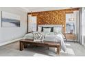 Cozy bedroom featuring a king bed, wood accent wall, and natural light from the dual windows at 8846 Yates Dr, Westminster, CO 80031