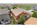 Aerial view of backyard featuring wood deck, privacy fence, and mature trees at 1836 Taos St, Brighton, CO 80603