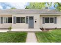 Close up of single story home featuring a well kept lawn and walkway to the grey front door at 2986 S Elm St, Denver, CO 80222