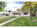 Quaint single-story home featuring a well-kept lawn, walkway, and an attached garage at 2986 S Elm St, Denver, CO 80222