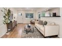 Bright living room features wood floors, neutral paint, modern furnishings and an open floor plan at 2986 S Elm St, Denver, CO 80222
