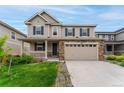 Charming two-story home featuring a stone facade, attached two car garage, and manicured front yard at 4666 S Malaya Ct, Aurora, CO 80015