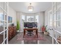 Bright home office featuring hardwood floors, large windows with great natural light, and a stylish light fixture at 12510 Fisher St, Englewood, CO 80112