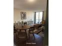 Bright, virtually staged living room with wood floors, shelving, and access to a balcony at 2500 S York St # 401, Denver, CO 80210