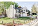 View of home with manicured lawn, fenced yard, and two-car garage on a sunny day at 10422 Nelson Ct, Broomfield, CO 80021