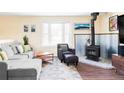 Comfortable living space with a black wood-burning stove, dark armchair, and a bright window at 10422 Nelson Ct, Broomfield, CO 80021