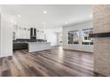 Open-concept living area with hardwood floors, a fireplace, and an adjacent kitchen creates a great flow at 9688 Winterset Cir, Littleton, CO 80125