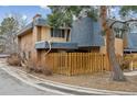 Townhome with a blue roof, brick accents, and a charming wood fence at 7995 E Mississippi Ave # 24, Denver, CO 80247