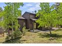 Beautiful wood-sided home with inviting entryway and mature trees at 30866 Kings Valley Way, Conifer, CO 80433