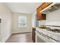 Bright kitchen with wooden floors, white appliances, and window view at 1340 Iola St, Aurora, CO 80010