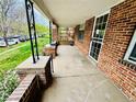 Covered porch with brick columns, concrete floor, and view of the front yard at 767 S York St, Denver, CO 80209