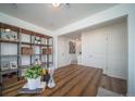 Well-lit office space showcasing a wooden desk and shelving unit for storage and decor at 13545 E 103Rd Ave, Commerce City, CO 80022