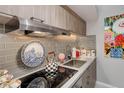 Kitchen featuring stainless steel appliances, gray tiled backsplash, and granite countertops at 2 Adams St # 809, Denver, CO 80206