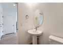 Powder room with pedestal sink and sleek fixtures creating a modern design at 1280 S Algonquian St, Aurora, CO 80018
