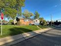 Brick home with solar panels, beautiful lawn, a paved walkway and a bright blue garage door at 6107 Xenon St, Arvada, CO 80004