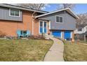 Close up view of the front of this brick home, showing the entry and blue garage doors at 6107 Xenon St, Arvada, CO 80004