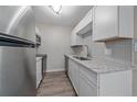 Well-lit kitchen with white cabinets, stainless steel appliances, and sleek countertops at 4110 Hale Pkwy # 1E, Denver, CO 80220