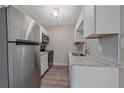 A compact kitchen showcasing stainless steel appliances, granite countertops, and white cabinets at 4110 Hale Pkwy # 1E, Denver, CO 80220