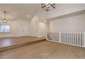 Bright living room with vaulted ceilings, hardwood floors, and staircase at 6055 W Warren, Lakewood, CO 80227