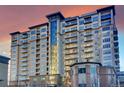 Luxury high-rise condominium featuring private balconies and stunning architectural design against an orange sunset at 5455 Landmark Pl # 1116, Greenwood Village, CO 80111