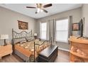 Cozy bedroom with a decorative wrought iron bed frame, ceiling fan, and natural light from two windows at 11865 Barrentine Loop, Parker, CO 80138