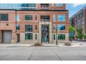 Close-up of a brick apartment building with large windows and concrete entrance at 1700 Bassett St # 101, Denver, CO 80202