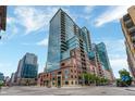 Modern high-rise apartment building with glass and brick exterior against a clear blue sky at 1700 Bassett St # 101, Denver, CO 80202