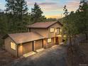Mountain home with a two-car garage and a balcony overlooking the natural scenery at 30938 Niakwa Rd, Evergreen, CO 80439