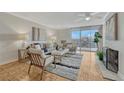 Bright living room featuring hardwood floors, a cozy fireplace, neutral decor, and a sliding glass door to a balcony at 4800 E Hale Pkwy # 802N, Denver, CO 80220