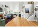Open concept living and dining area with hardwood floors and modern staircase at 2635 Pierce St, Wheat Ridge, CO 80214