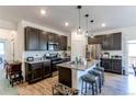 Modern kitchen with dark cabinetry, granite counters, and island at 2937 Pershing St, Strasburg, CO 80136