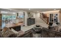 Open-concept living space with elegant staircase, view to kitchen, and comfortable, plush furnishings at 7750 S Glencoe Way, Centennial, CO 80122