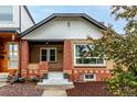 A charming brick home showcases a cozy front porch and well-maintained landscaping at 1463 Dahlia St # 2, Denver, CO 80220