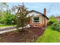 A beautifully landscaped yard with a tree adds to the curb appeal of the home at 1463 Dahlia St # 2, Denver, CO 80220