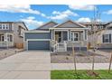 Charming single-Gathering home featuring a covered porch, well-kept lawn, and a two-car garage at 13392 E 110Th Way, Commerce City, CO 80022