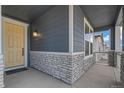 Inviting front porch with stone accents, a bright yellow door, and ample space for relaxing at 13392 E 110Th Way, Commerce City, CO 80022