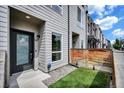 Front door of a modern townhome with a small patch of artificial turf and wood privacy fence at 3520 W Conejos Pl # 14, Denver, CO 80204