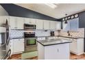 Bright kitchen featuring white cabinets, stainless steel appliances, and ample counter space for cooking at 9694 Canberra Dr, Highlands Ranch, CO 80130