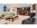 Cozy living room featuring a large bookcase, classic furnishings, and neutral carpet at 10130 E Powers Ave, Greenwood Village, CO 80111