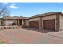 Stunning exterior elevation with a circular driveway, stone accents, and an attached three car garage at 5265 Club Ct, Larkspur, CO 80118