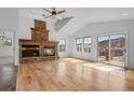 Light-filled living room boasts a stone fireplace, vaulted ceilings, and sliding door access at 5265 Club Ct, Larkspur, CO 80118