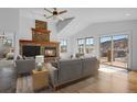 Bright living room featuring a stone fireplace, vaulted ceilings, hardwood floors and mountain views at 5265 Club Ct, Larkspur, CO 80118