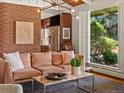 Bright living room with exposed brick and stainless steel appliances in an open layout at 10400 W 35Th Pl, Wheat Ridge, CO 80033
