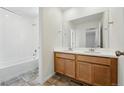 Bright bathroom featuring double sinks, wood cabinets and a shower over tub at 2079 Generations Aly, Brighton, CO 80601