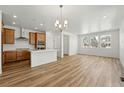 Bright, open-concept living space features wood floors, recessed lighting, and kitchen with a center island at 2079 Generations Aly, Brighton, CO 80601