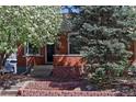 Quaint brick home entrance with lush landscaping and mature tree at 3391 W 32Nd Ave, Denver, CO 80211