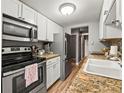 Modern kitchen with stainless steel appliances, granite countertops, and white cabinetry at 100 S Clarkson St # 202, Denver, CO 80209