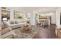 Bright living room with modern furnishings, hardwood floors, and view into an adjacent dining area and the kitchen at 4674 Flower St, Wheat Ridge, CO 80033